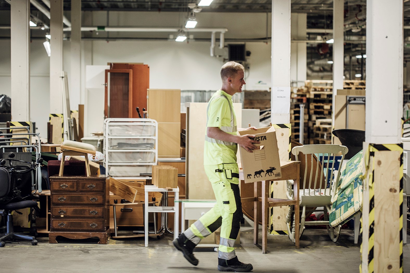 En person i Returen lyfter en kartong