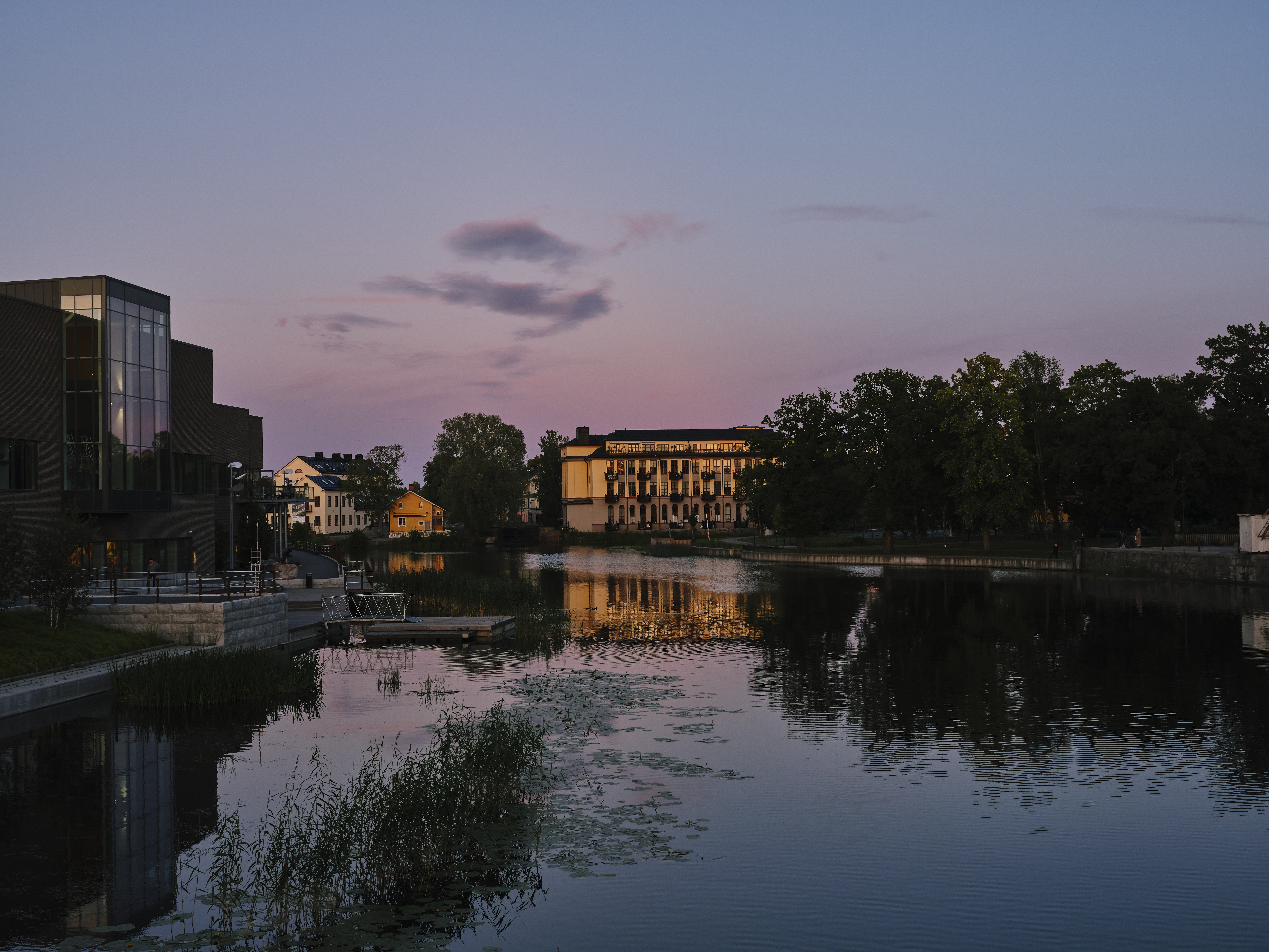 Eskilstuna stadsmuseum i skymning med reflektion i Eskilstunaån.
