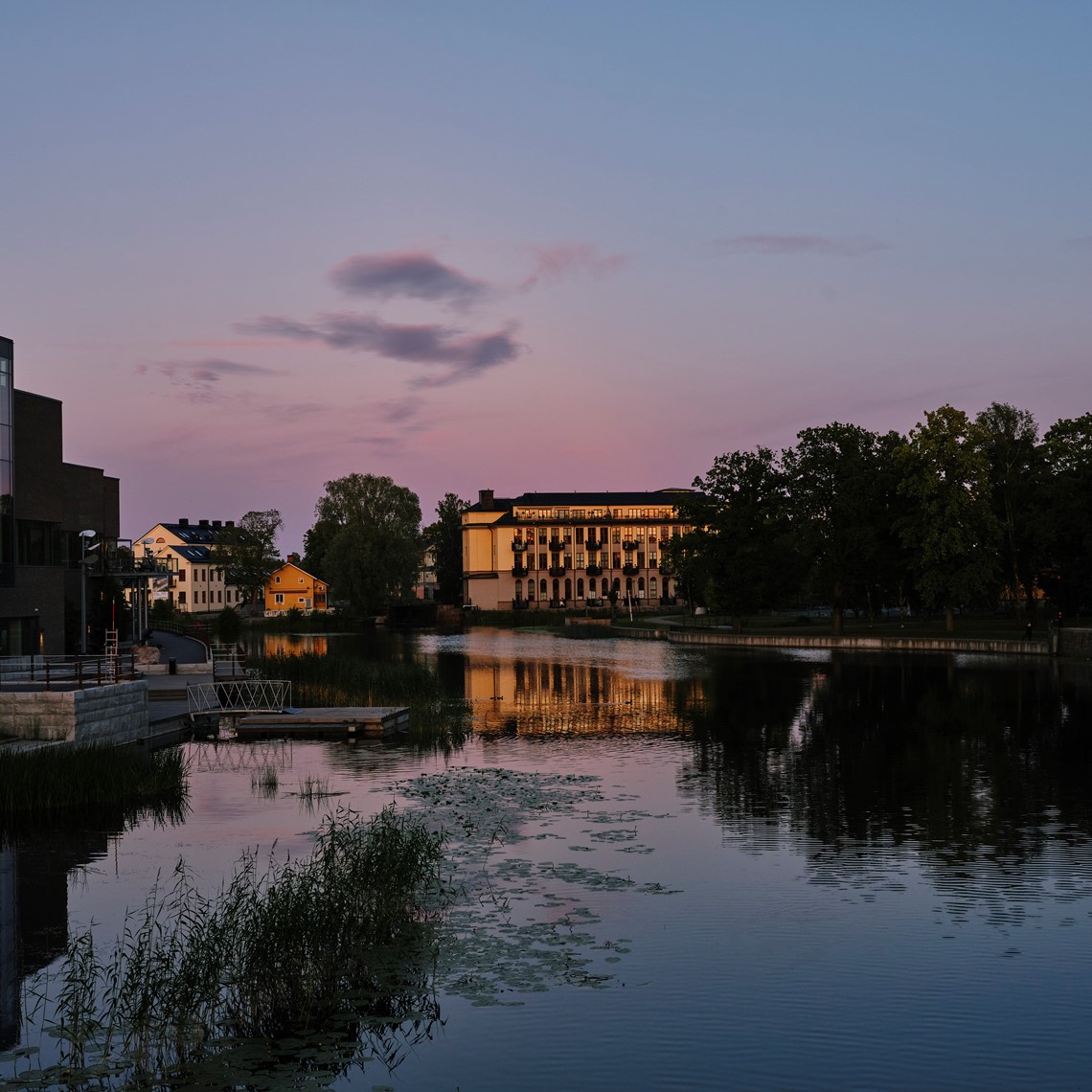 Eskilstuna stadsmuseum i skymning med reflektion i Eskilstunaån.