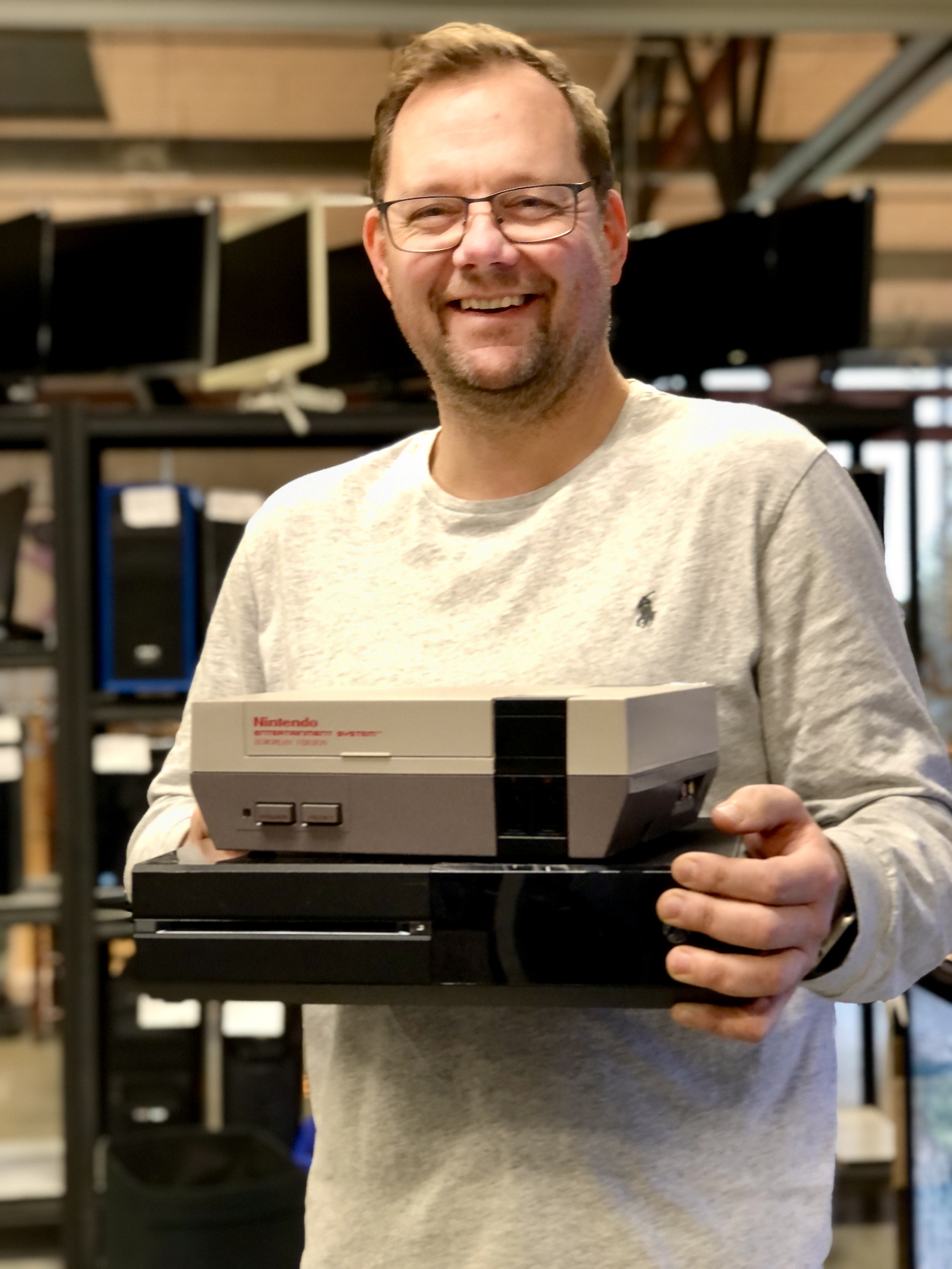 Thomas håller upp två spelkonsoller