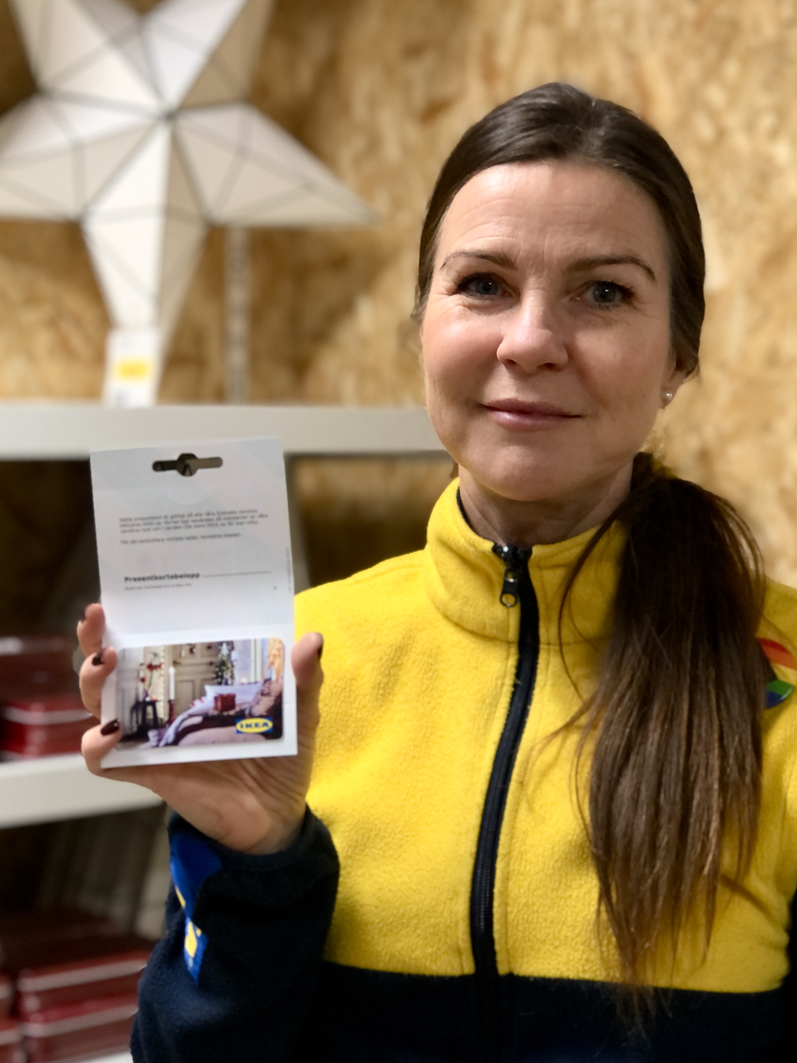 Ikea personal håller upp presentkort